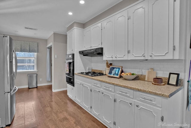 kitchen featuring tasteful backsplash, black gas cooktop, white cabinetry, light hardwood / wood-style flooring, and stainless steel fridge