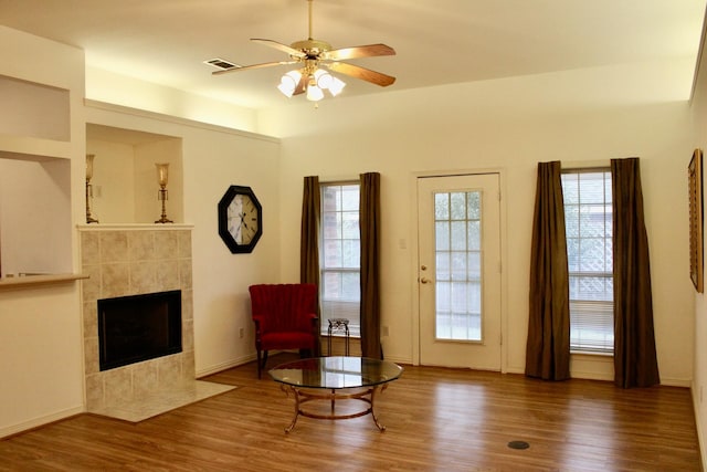 unfurnished room with dark wood-type flooring, ceiling fan, and a fireplace