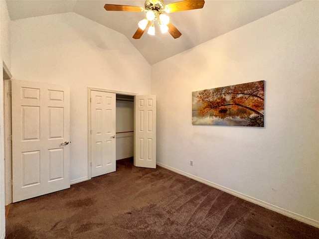 unfurnished bedroom with ceiling fan, a closet, lofted ceiling, and dark colored carpet