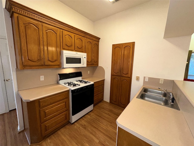 kitchen featuring sink, range with gas stovetop, and hardwood / wood-style flooring