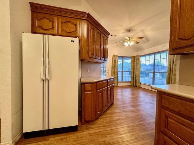 kitchen featuring ceiling fan, light hardwood / wood-style flooring, white refrigerator, and vaulted ceiling