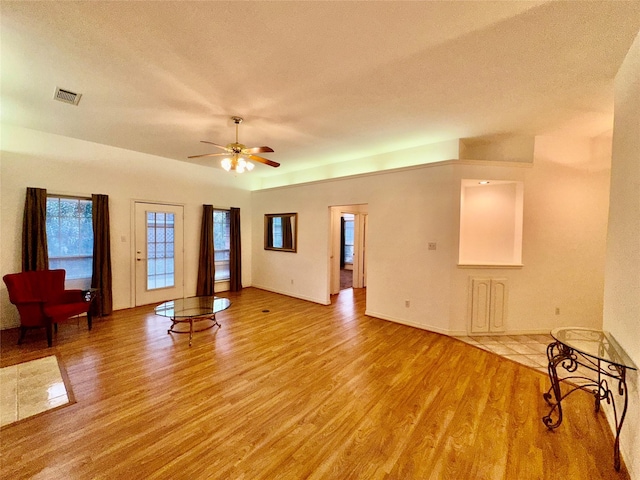 unfurnished living room featuring ceiling fan, a textured ceiling, and light hardwood / wood-style flooring