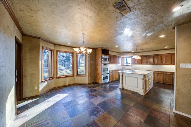 kitchen featuring stainless steel appliances, a kitchen island, decorative backsplash, and decorative light fixtures