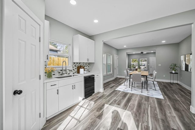 kitchen featuring dark wood-type flooring, white cabinetry, sink, backsplash, and ceiling fan