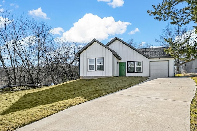 modern inspired farmhouse with a garage and a front lawn