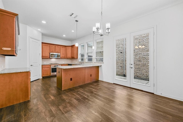 kitchen with stainless steel appliances, sink, backsplash, hanging light fixtures, and kitchen peninsula