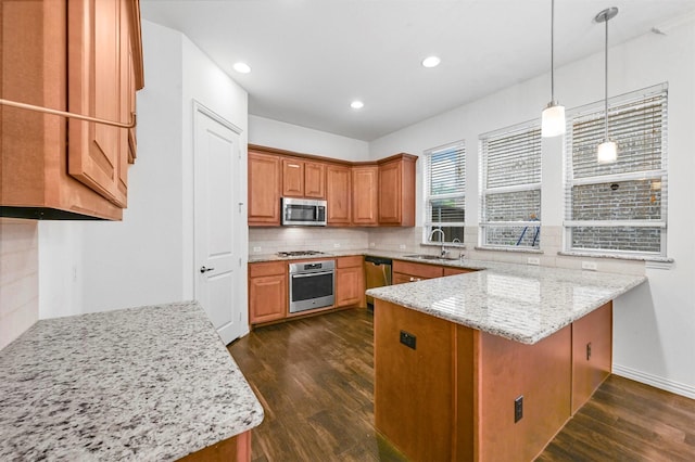 kitchen with dark hardwood / wood-style floors, sink, hanging light fixtures, light stone countertops, and stainless steel appliances