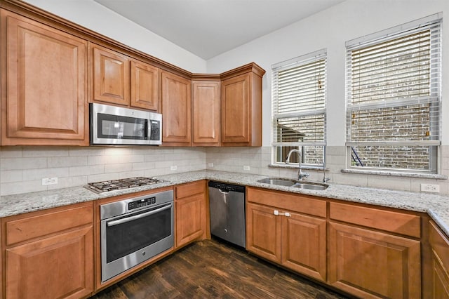 kitchen featuring dark hardwood / wood-style flooring, sink, light stone counters, and stainless steel appliances