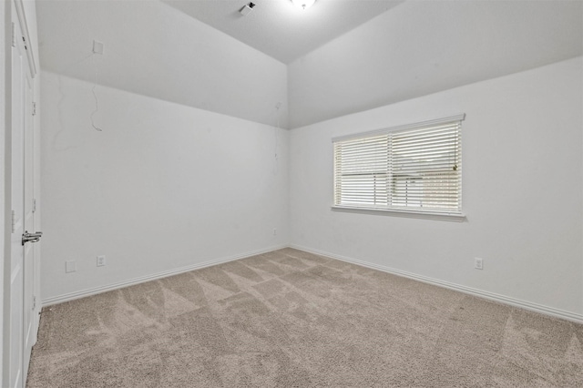 carpeted empty room with lofted ceiling