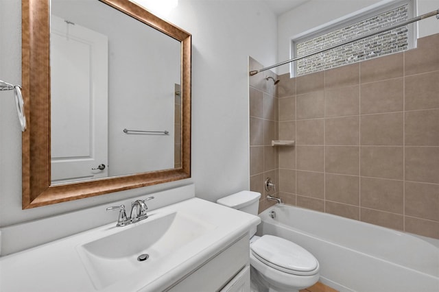 full bathroom featuring tiled shower / bath combo, vanity, and toilet