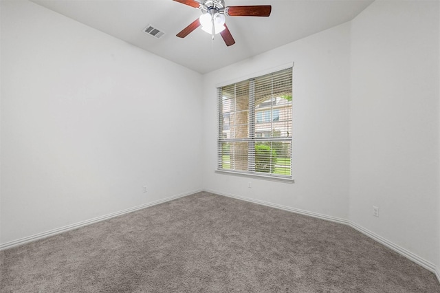 empty room featuring ceiling fan and carpet