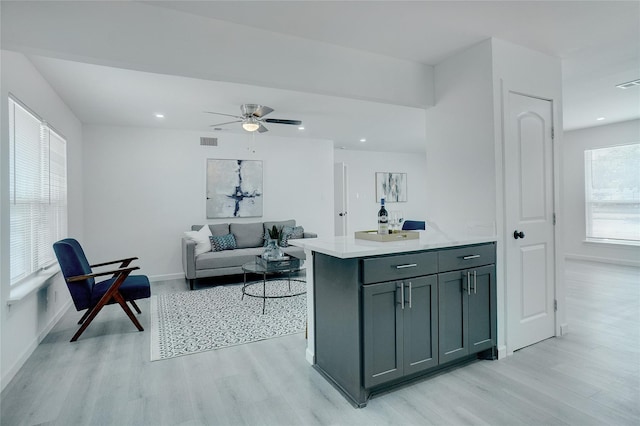 kitchen featuring ceiling fan, gray cabinetry, and light hardwood / wood-style flooring