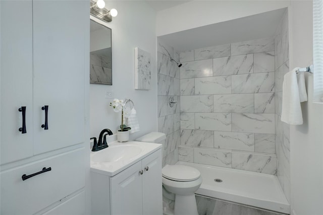 bathroom featuring hardwood / wood-style floors, tiled shower, vanity, and toilet