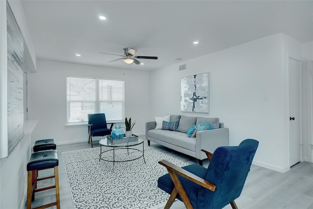 living room featuring ceiling fan and light hardwood / wood-style flooring