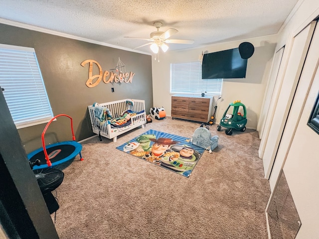 bedroom with a nursery area, carpet, ornamental molding, and a textured ceiling