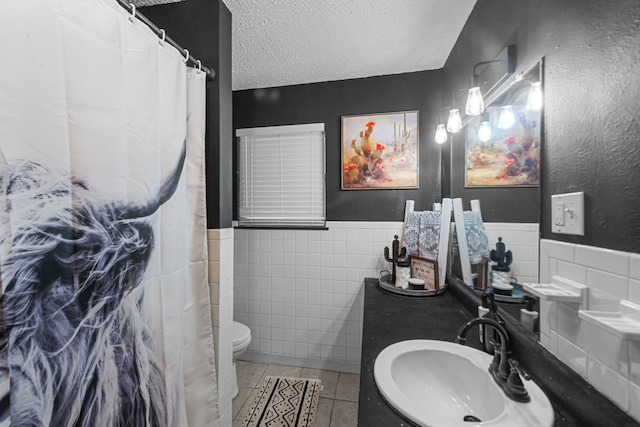 bathroom featuring sink, tile walls, a textured ceiling, and tile patterned flooring