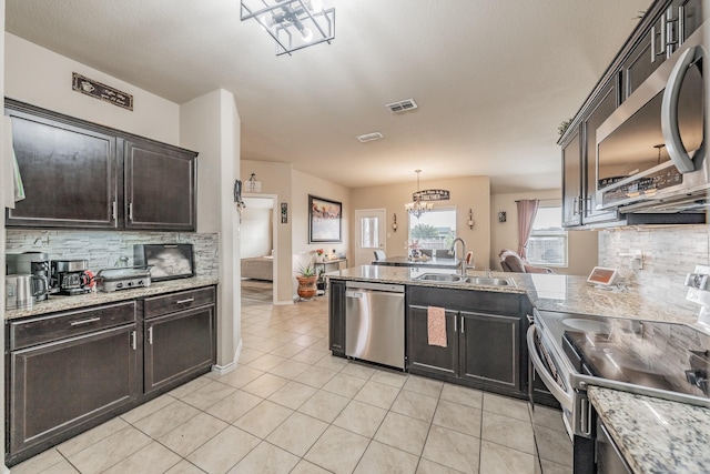 kitchen featuring light tile patterned floors, stainless steel appliances, tasteful backsplash, pendant lighting, and sink