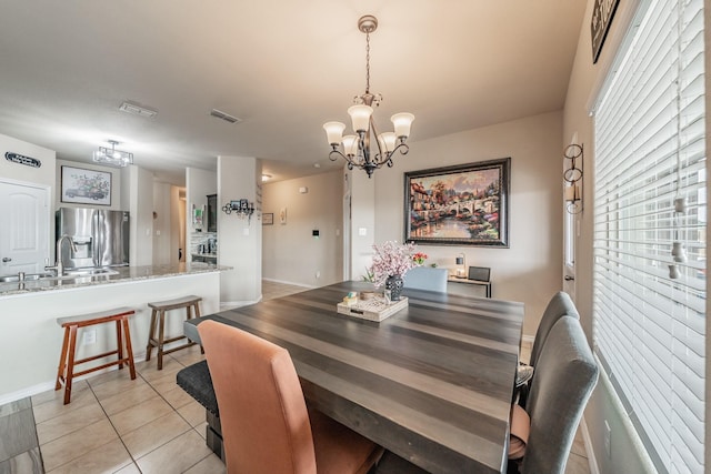 tiled dining room featuring sink and an inviting chandelier