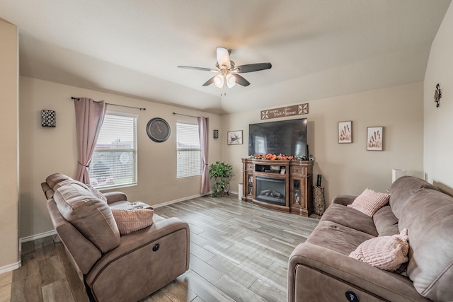 living room with ceiling fan, a fireplace, and light hardwood / wood-style flooring