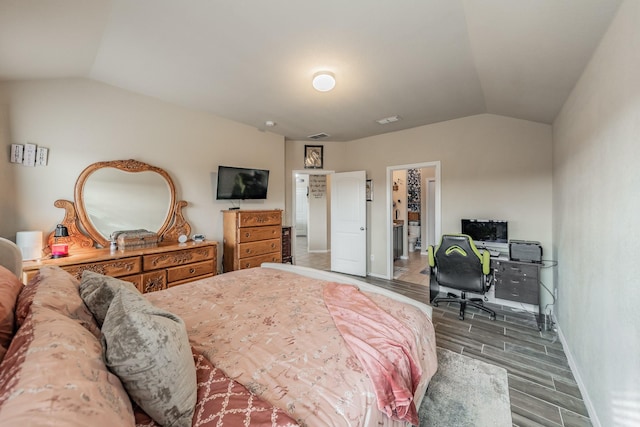 bedroom with lofted ceiling, a spacious closet, and hardwood / wood-style floors