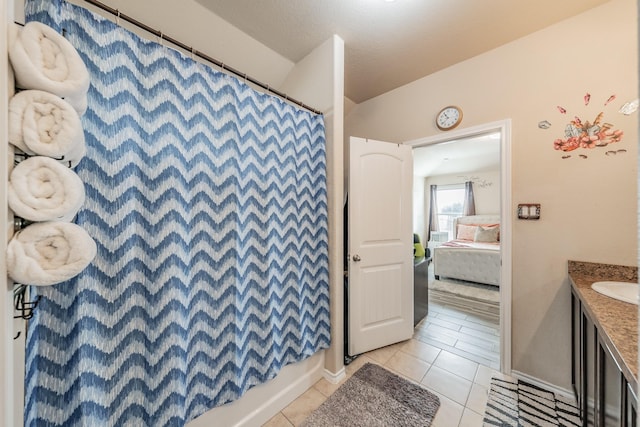 bathroom with a textured ceiling, shower / tub combo, tile patterned floors, and vanity