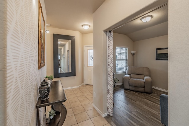 hall with light hardwood / wood-style floors and lofted ceiling