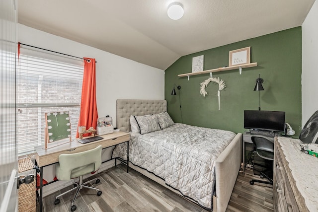 bedroom with vaulted ceiling and hardwood / wood-style floors