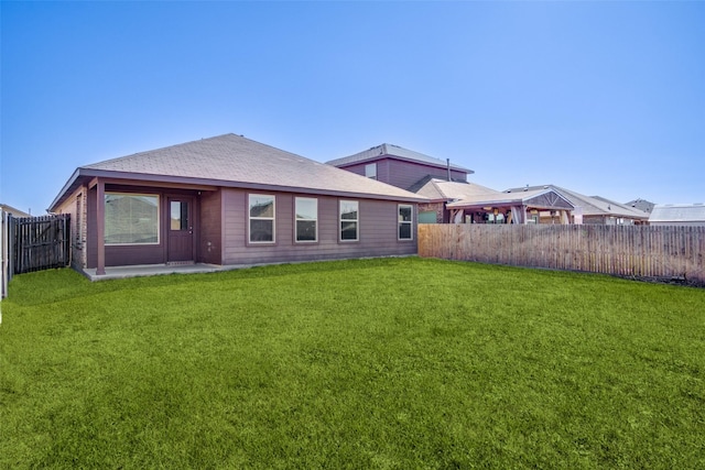 rear view of house featuring a lawn