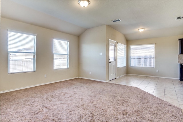 tiled empty room with lofted ceiling