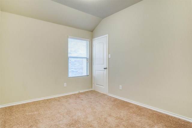 unfurnished room with light colored carpet and lofted ceiling