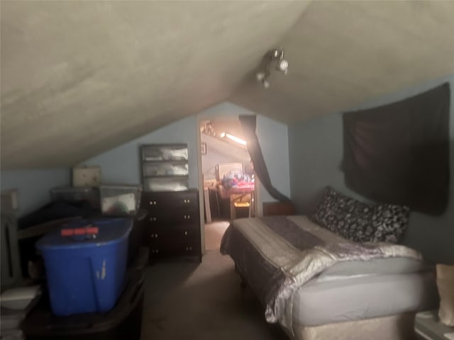 bedroom featuring lofted ceiling and dark colored carpet