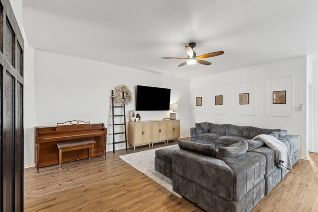 living room featuring ceiling fan and light hardwood / wood-style floors