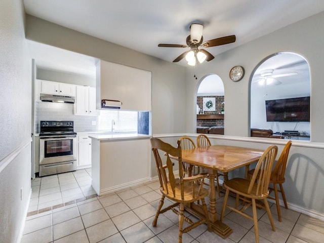 tiled dining area featuring ceiling fan and sink