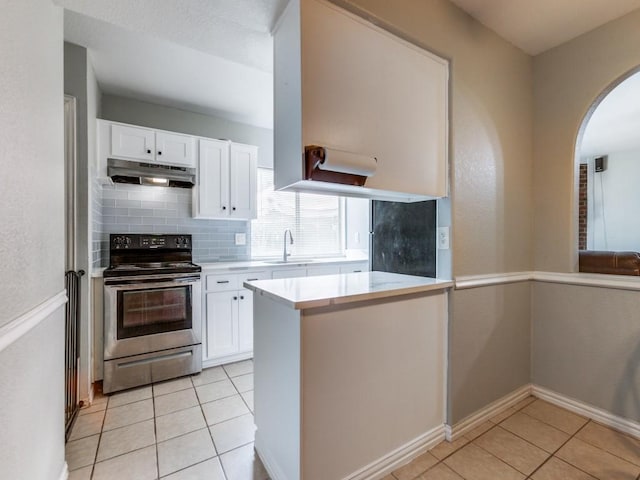 kitchen with sink, white cabinets, stainless steel range with electric stovetop, and tasteful backsplash