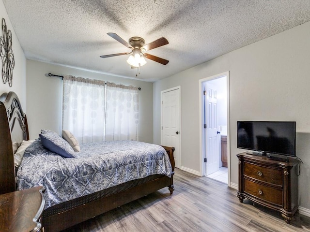 bedroom featuring a textured ceiling, ceiling fan, ensuite bathroom, and light hardwood / wood-style floors