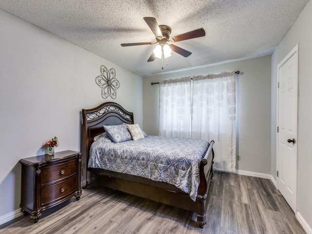 bedroom with ceiling fan, a textured ceiling, and hardwood / wood-style flooring