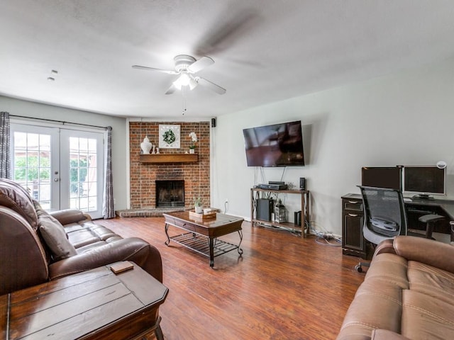 living room featuring ceiling fan, hardwood / wood-style floors, a fireplace, and french doors