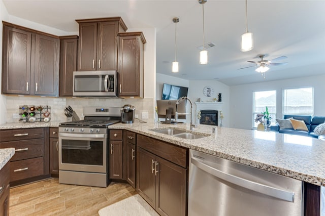 kitchen featuring hanging light fixtures, backsplash, appliances with stainless steel finishes, and sink