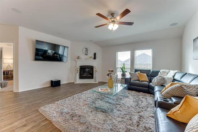 living room with ceiling fan, lofted ceiling, and hardwood / wood-style floors