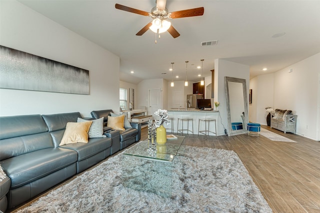 living room featuring ceiling fan and light hardwood / wood-style flooring