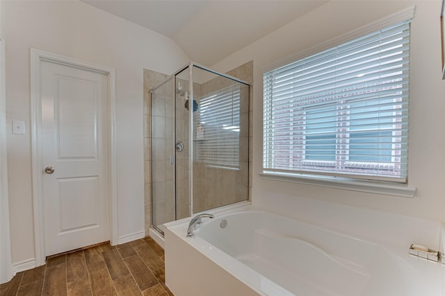 bathroom featuring independent shower and bath and lofted ceiling