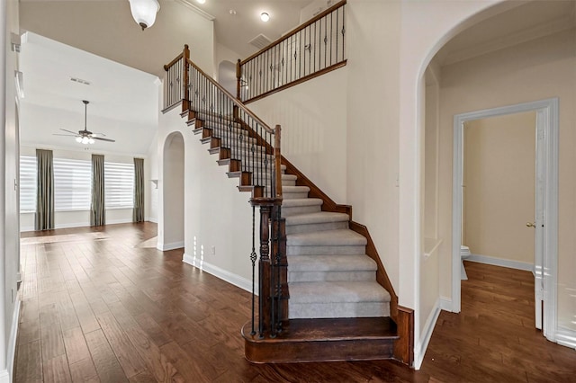 staircase with hardwood / wood-style flooring, ornamental molding, and ceiling fan