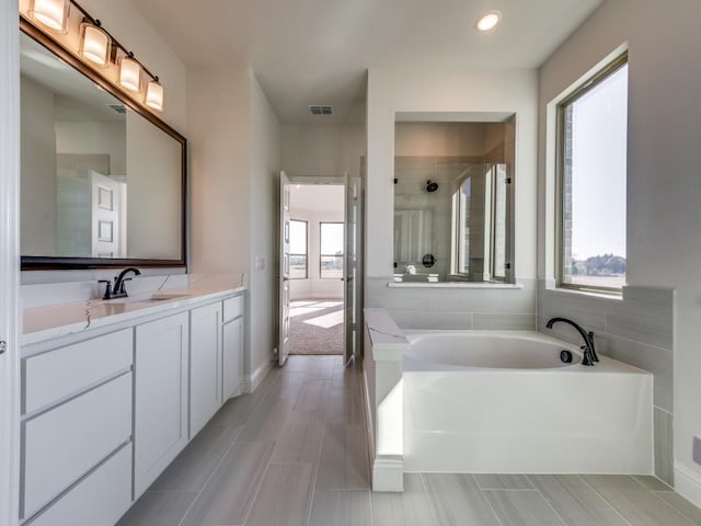 bathroom featuring a washtub and vanity