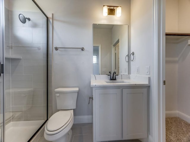 bathroom featuring toilet, tiled shower, and vanity