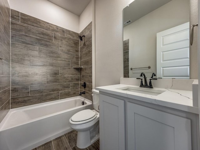 full bathroom featuring toilet, tiled shower / bath combo, and vanity