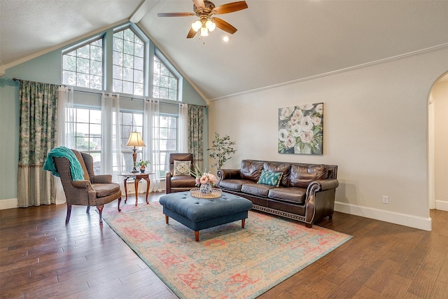 living room featuring dark wood-type flooring, crown molding, high vaulted ceiling, and ceiling fan