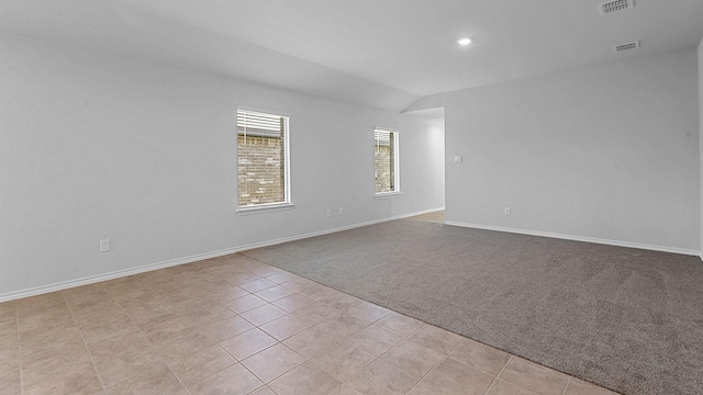 carpeted spare room with lofted ceiling