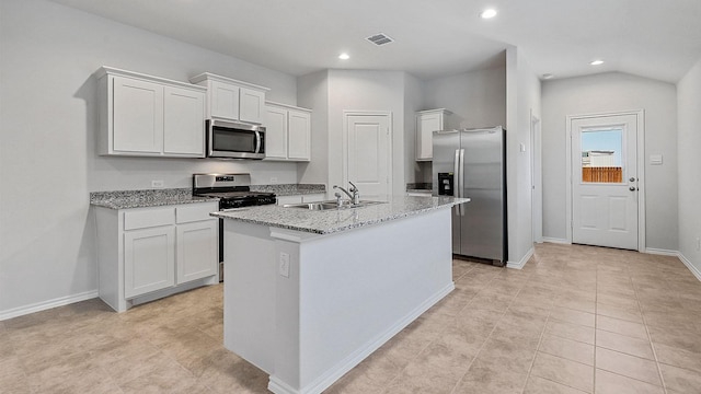 kitchen with sink, white cabinets, appliances with stainless steel finishes, and a center island with sink