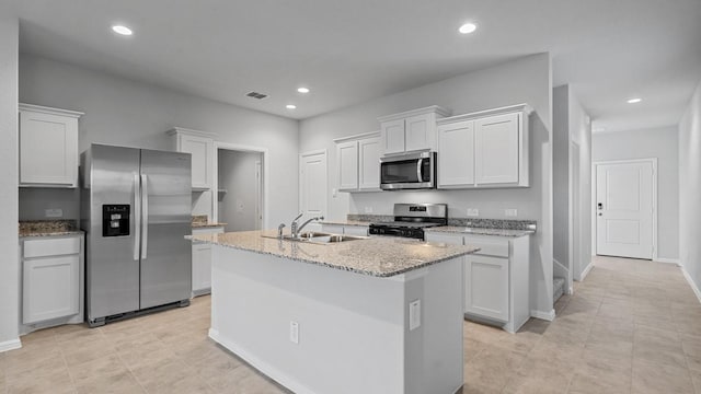 kitchen featuring a center island with sink, sink, stainless steel appliances, and white cabinetry