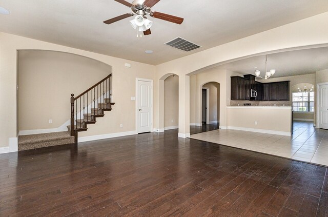 kitchen with appliances with stainless steel finishes, sink, backsplash, light stone counters, and dark brown cabinets